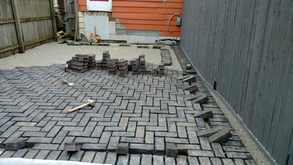 Herringbone permeable pavers being laid over a prepared base