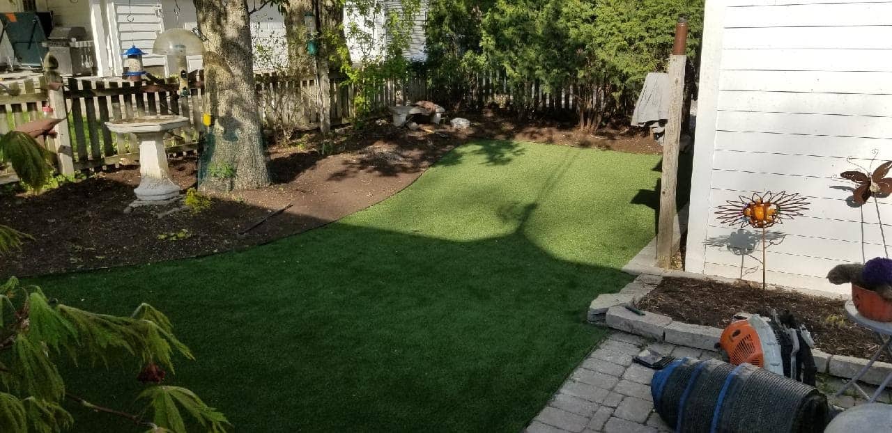 Artificial turf lawn installed in a shaded Chicago-area backyard
