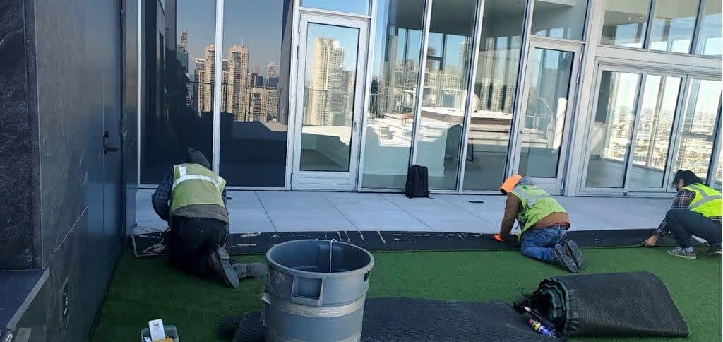 Streamline crew installing artificial turf on a downtown Chicago high-rise terrace