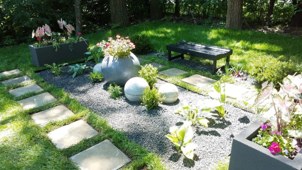 Backyard garden with bluestone stepping stones, gravel beds and container plantings