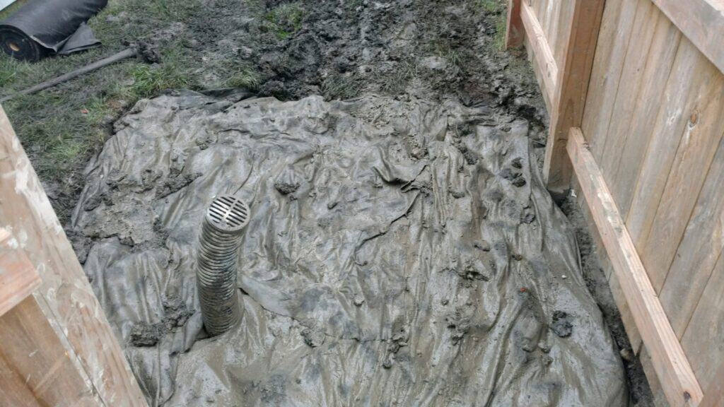Dry well wrapped in filter fabric with its inlet pipe, ready to be backfilled