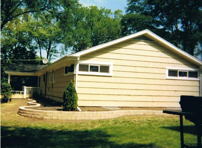Multilevel Garden Stone retaining wall wrapping around a ranch home