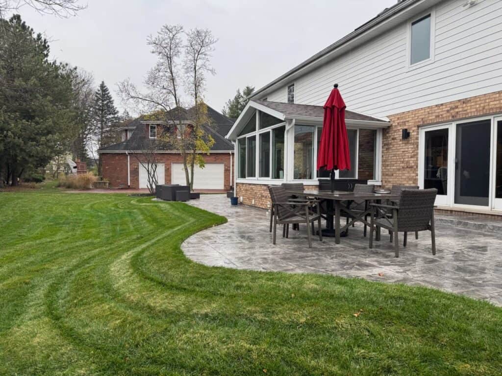 Curved stamped concrete patio wrapping the back of the house