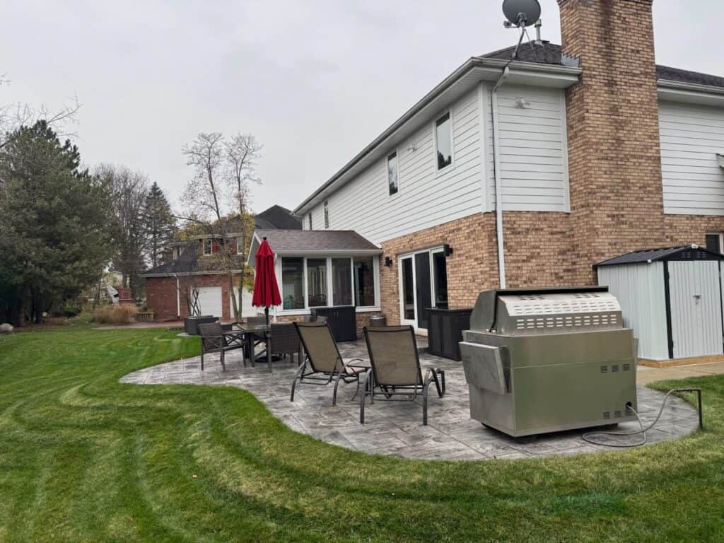 Stamped concrete patio seen from the corner of the yard